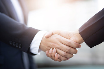 Closeup of a businessman hand shake businesswoman between two colleagues  OK, succeed in business Holding hands.