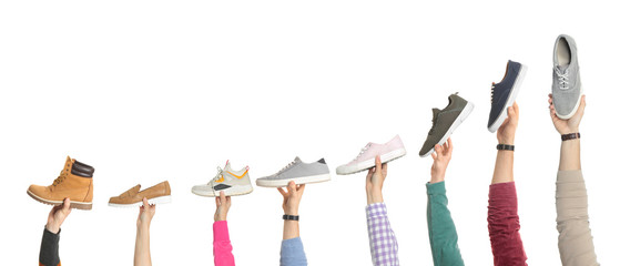 Set of people holding different stylish shoes on white background, closeup