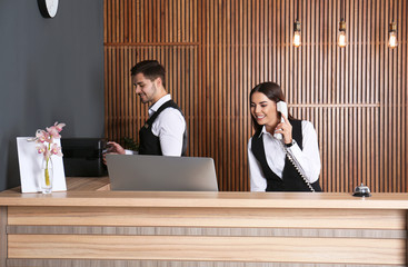 Receptionists working at desk in modern lobby