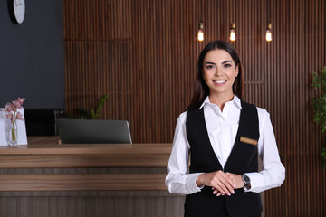 Portrait of receptionist at desk in lobby - obrazy, fototapety, plakaty