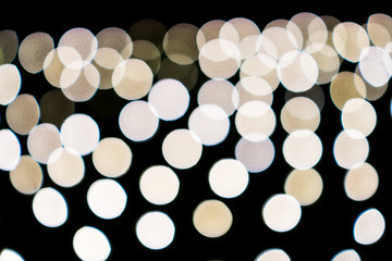 Abstract white yellow bokeh lights on road street in city night light background, decoration in soft for greeting card backdrop with glitter sparkle blurred circles