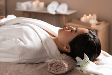 Obraz na płótnie Canvas Beautiful Asian woman lying on massage table in spa salon
