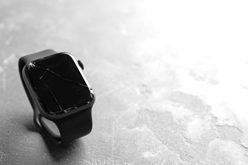 Broken smart watch on grey background, space for text. Repair service