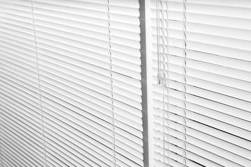 Window with closed white horizontal blinds as background