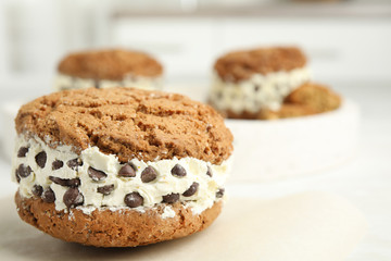 Fototapeta na wymiar Sweet delicious ice cream cookie sandwich with chocolate chips on table, closeup. Space for text