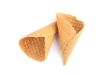 Empty crispy waffle cones for ice cream on white background, top view