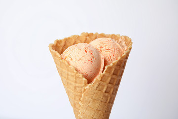 Delicious ice cream in waffle cone on white background