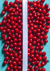 Cherry background with white ribbon. Fresh organic berries. Pile of ripe cherries