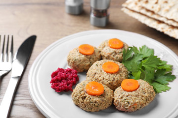 Plate of traditional Passover (Pesach) gefilte fish on wooden table, closeup