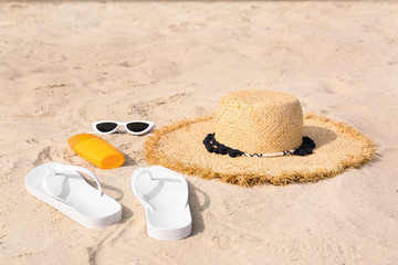 Set of different stylish beach accessories on sand