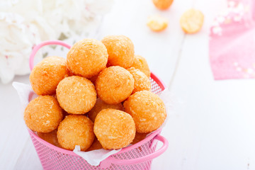 Homemade cheese balls in a pink basket on a white table, horizontal, copy space