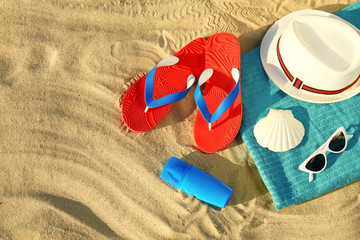 Flat lay composition with stylish beach accessories on sand. Space for text