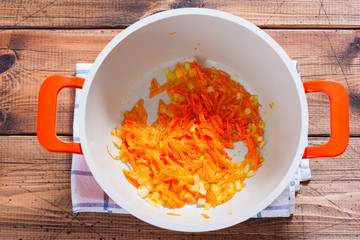 Step by Step Cooking of Red Lentil Soup - Step 2 - Frying Onions and Carrots, top view, horizontal