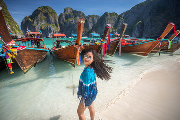 Young asian woman posting on the Maya bay