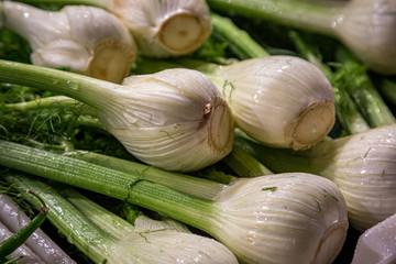 A close up of fennel bulbs on a market stall with a shallow depth of field