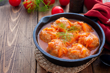 beef meatballs cooked with rice in tomato sauce decorated with basil
