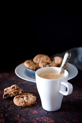 Cookies with chocolate and hazelnuts, perfect for coffee or tea in the afternoon. Brown board and dark background