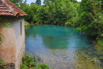 Amazingly beautiful mountain's spring with heavenly blue water color and small waterfall named Krupajsko Vrelo (spring of Krupaj), near Krupaja village, Eastern Serbia 