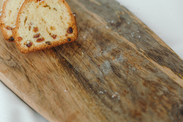 Raisin cake, dusted with icing sugar. Cupcake with raisins on a wooden board