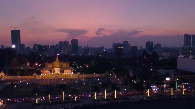Vertigo drone clip of the Royal palace and downtown of Phnom Penh, Cambodia, at night. Crazy traffic congestion on the riverside in front of it