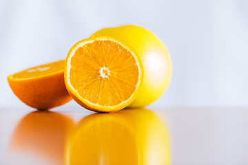 Fresh oranges on reflective wooden table