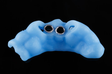 Dental blue pattern on a black background, intended for the implantation of the front upper teeth