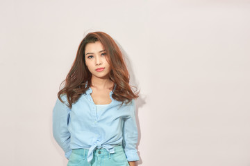Obraz premium Beautiful lady in trendy blue blouse looking at camera with confident face expression while standing on light pink background