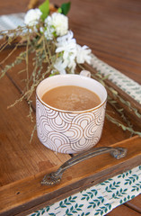 White Coffee Cup on wooden tray with white flowers