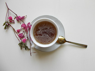 Tea in a white Cup, with pink flowers