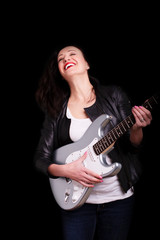 Beautiful dark girl playing guitar in rock style on a black background.