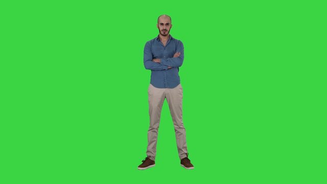 Serious confident arabian man in casual folds hands looking into camera on a Green Screen, Chroma Key.