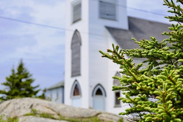 Pine branch with church in defocused back ground, no people.