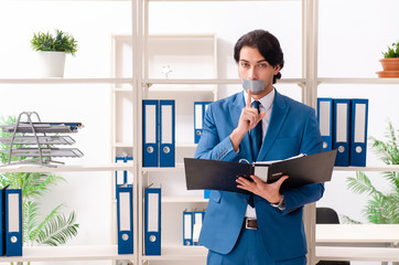 Fototapeta premium Young male employee with tape on the mouth 