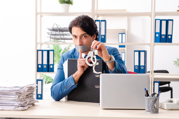 Young male employee with tape on the mouth 