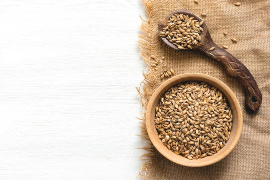 Malt In A Wooden Bowl On The White Kitchen Table Background.