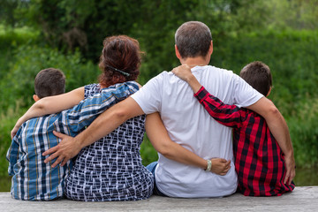 Family sitting on the pier in the nature