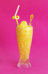 Glass of passion fruit smoothie on pink background