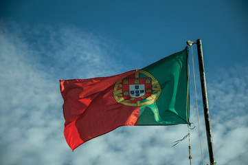 Portuguese flag fluttering on blue sky