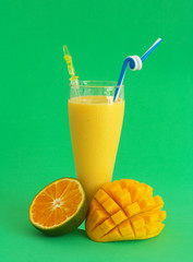 Mango with orange smoothie with mango and orange fruit on green background
