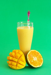 Mango with orange smoothie with mango and orange fruit on green background