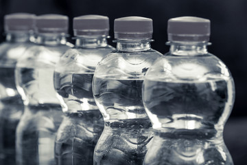 Row of water bottles, bubbling spa red, recycling environment concept black and wite