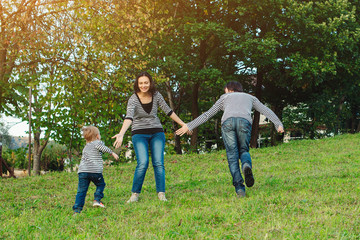 Obraz premium Happy family having fun outdoors.Young family enjoying life, together on nature. Happy family lifestyle. Family look. Concept of friendly family. Family vacations in countryside.