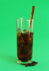 Vietnamese iced coffee with golden spoon on green background