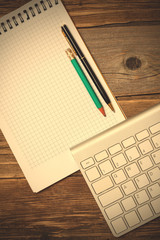 notebook on a spring, vintage pencil, pen and computer keyboard