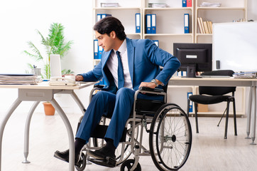 Male employee in wheelchair working at the office 