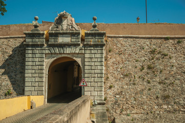 Deserted street going toward the city wall gateway and traffic sign
