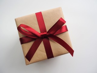 赤いリボンがかかった茶色いプレゼントの箱