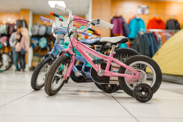 Rows of children's bicycles in sports shop, nobody