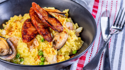A serving of seafood paella on a table with red and white napkins