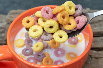 Un bol con aros de cereales de colores con leche